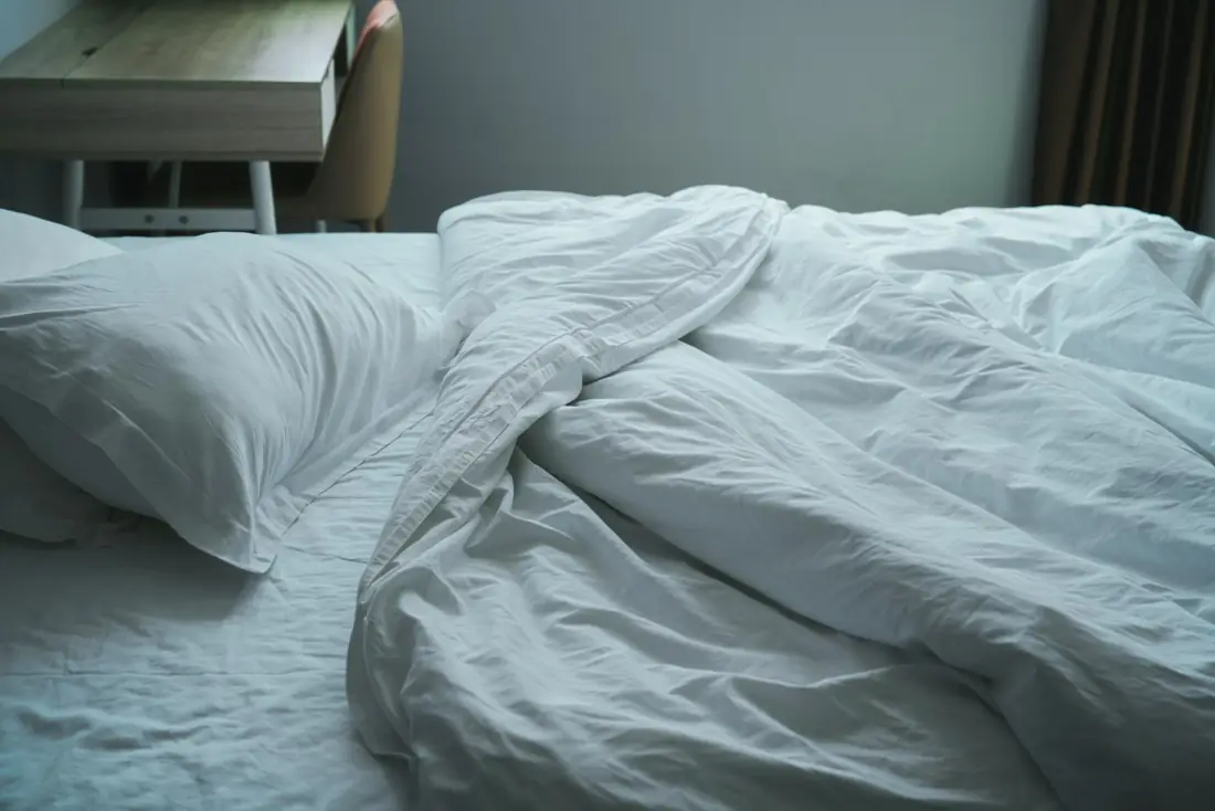 Draps et literie froissés sur un lit