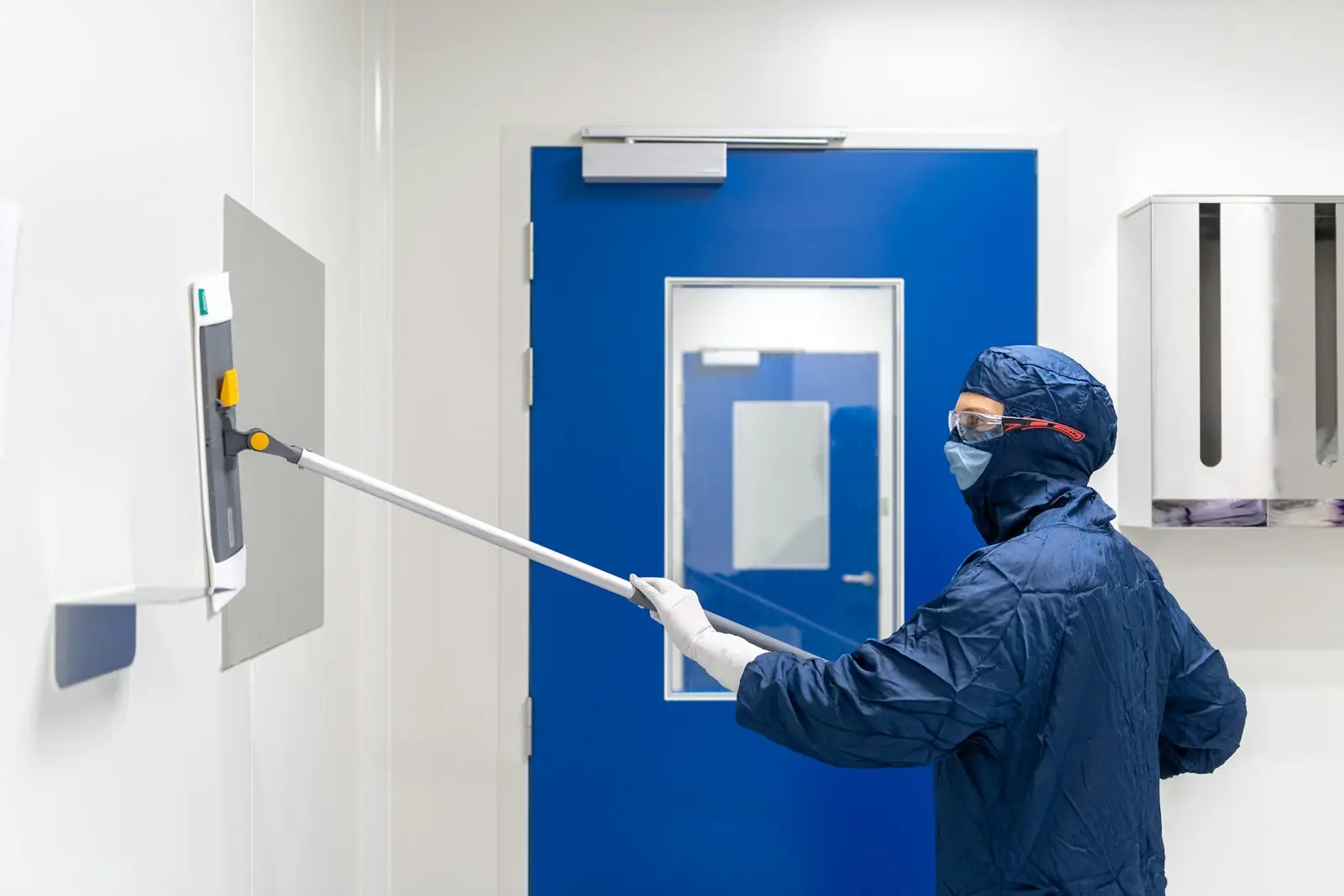 Technicien en tenue de protection intervenant dans des locaux professionnels